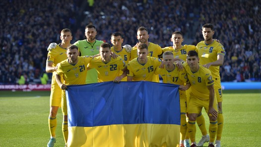 Interland in oorlogstijd: spelers Oekraïne komen met vlaggen het veld op