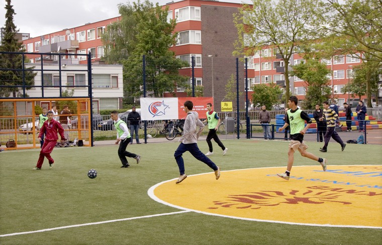 Jongeren vermaken zich tijdens een voetbaltoernooi op het Cruyff Court in de wijk Kanaleneiland in Utrecht.