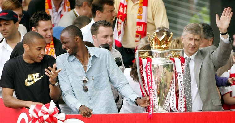 Thierry Henry (links), Patrick Vieira (midden) en Arsène Wenger (rechts) vieren in 2004 de landstitel met Arsenal, dat ongeslagen kampioen werd. 