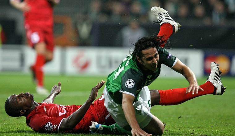 Douglas tijdens de Champions League in een duel met Claudio Pizarro van Werder Bremen.