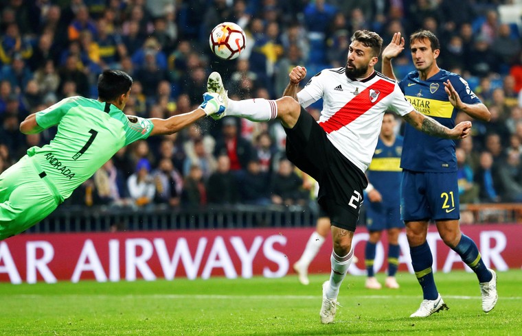 Namens River Plate speelt Lucas Pratto hoog spel tegen doelman Esteban Andrada in de beruchte finale om de Copa Libertadores tegen Boca Juniors, op 9 december 2018 in Madrid. River won met 3-1, Pratto scoorde één keer.