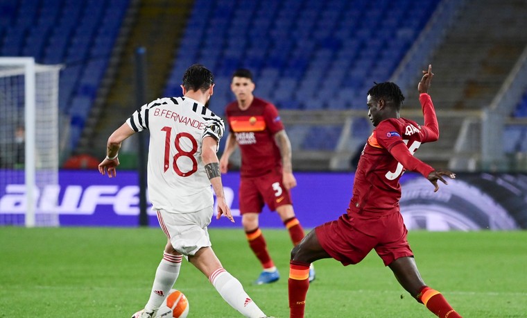 Ebrima Darboe probeert Manchester United-sterspeler Bruno Fernandes van de bal te zetten in de return van de halve finale van de Europa League.