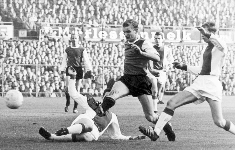 De editie van 1964/65 eindigde in een 9-4 overwinning voor Feyenoord. Hans Venneker maakt het tweede doelpunt voor de Rotterdammers, gehinderd door Kees Ruiter en de liggende Wim Suurbier.