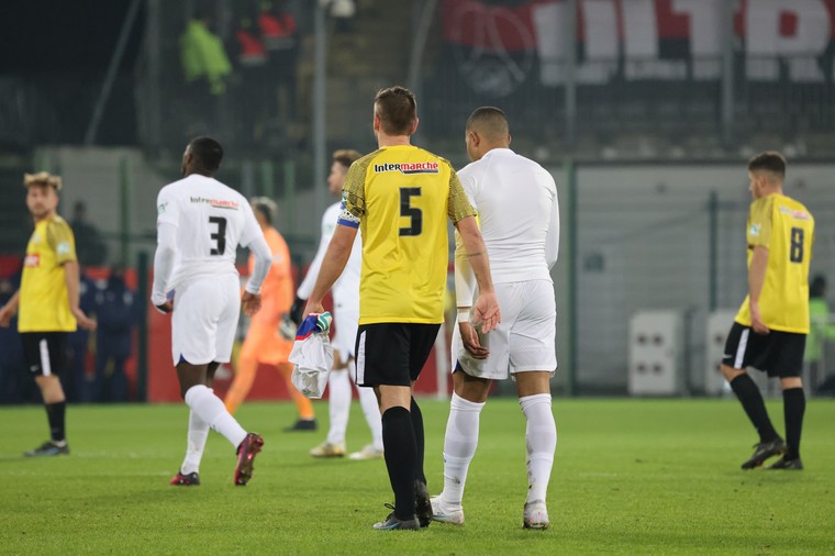 Alexis Zmijak loopt samen met Kylian Mbappé van het veld, met het wedstrijdshirt van de PSG-ster.