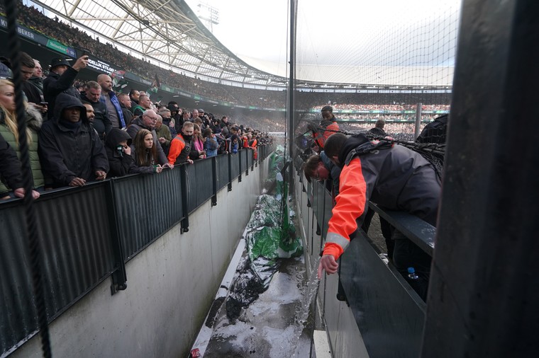 De bekerfinale werd ontsierd door vuurwerk. Hier probeert de brandweer een spandoek van de Feyenoord-fans dat vlam had gevat te blussen. 