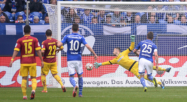 De bal verdwijnt in het Paderborn-doel na een kopduel tussen Uwe Hünemeier en Klaas-Jan Huntelaar.