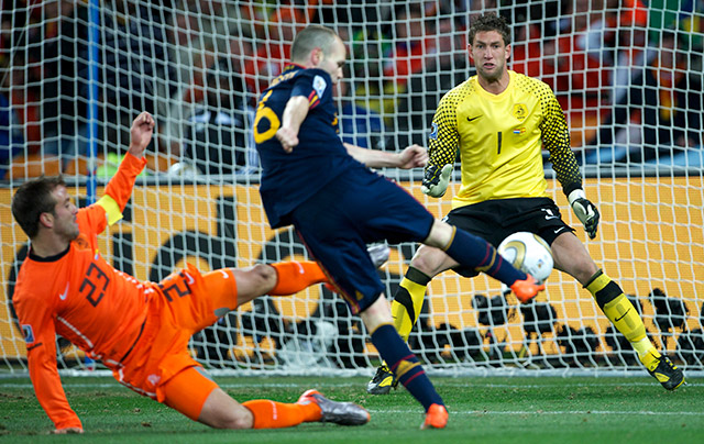 Het fatale moment van Oranje. Andres Iniesta is Rafael van der Vaart te snel af en schiet Spanje naar de wereldbeker.