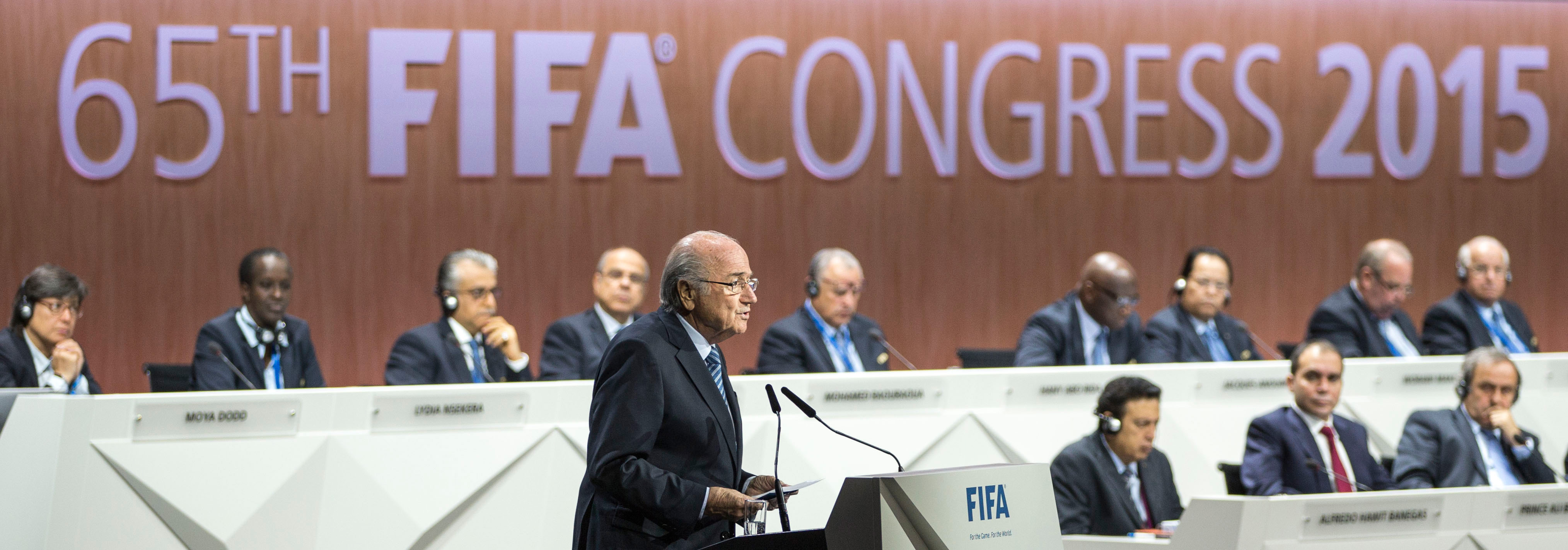 Sepp Blatter spreekt de zaal toe. Rechts onderin, als tweede van rechts, kijkt zijn tegenstrever Prins Ali toe. 