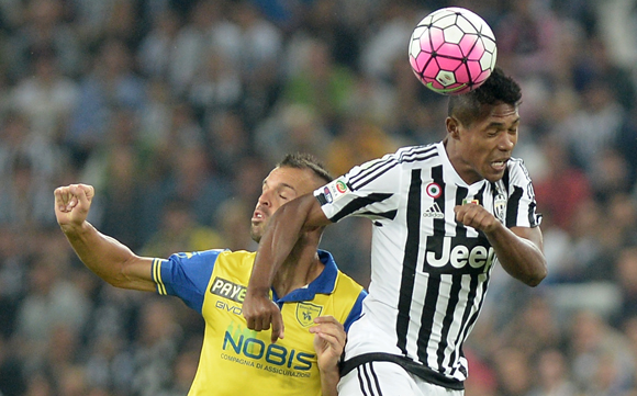 Juventus-verdediger Alex Sandro wint een kopduel van Riccardo Meggiorini.
