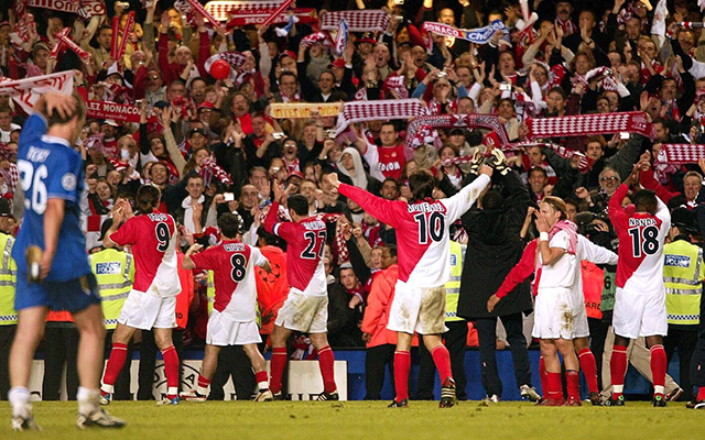De spelers van AS Monaco vieren feest met de meegereisde fans na het bereiken van de Champions League-finale. Op de voorgrond loopt de balende John Terry.