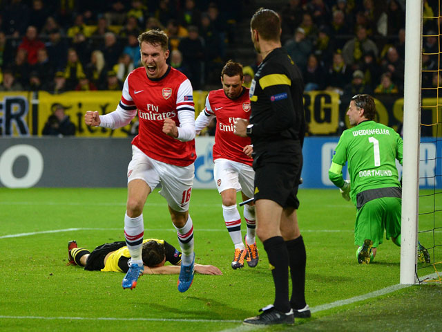 Matchwinner Ramsey en in zijn rug Santi Cazorla van Arsenal laten de Dortmunders Roman Weidenfeller en Neven Subotic balend achter.