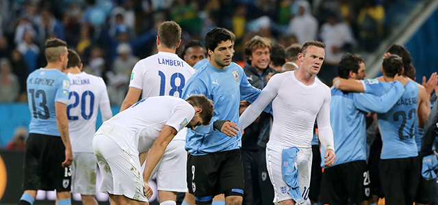 Steven Gerrard en Wayne Rooney druipen teleurgesteld af nadat ze Engeland tegen het Uruguay van Luis Suarez niet hebben kunnen behoeden voor uitschakeling.