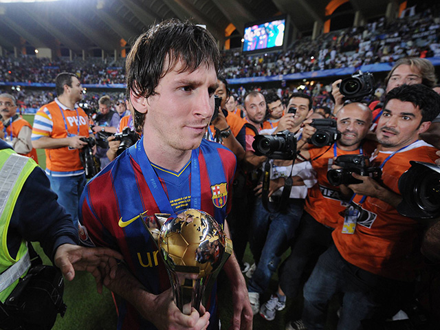 Messi poseert met de wereldbeker, de prijs die hij met Barcelona op 19 december 2009 in Abu Dhabi voor het eerst verovert. In de finale van het WK voor clubs tegen het Argentijnse Estudiantes tekent de dan 22-jarige aanvaller met zijn borst voor de winnende goal: 2-1. De Spaanse media beschrijven de treffer als &#039;een doelpunt gemaakt met het hart.&#039; 