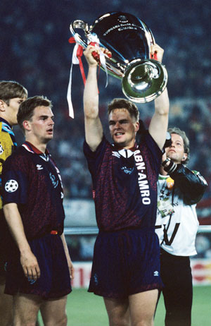 Frank de Boer tilt de Champions League-trofee in de lucht. Links zijn broer Ronald de Boer.