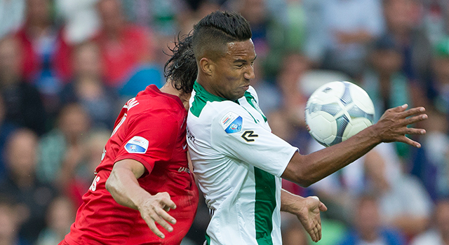 Georgios Katsikas zit Danny Hoesen, aangever bij de 1-1 van Groningen, op de huid.