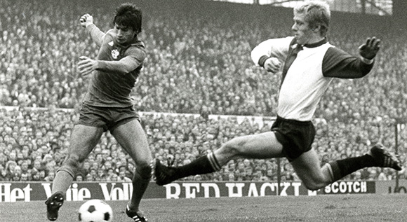 Wim Rijsbergen in dienst als Feyenoord-verdediger. Op de foto een kenmerkende tackle in een duel met Ajacied Tscheu La Ling.
