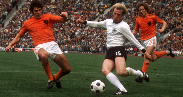 Uli Hoeness duelleert in de WK-finale van 1974 met Willem van Hanegem. Op de achtergrond Arie Haan.