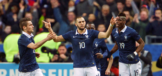 Karim Benzema viert de 1-0 en wordt bejubeld door Mathieu Debuchy (links) en Paul Pogba (rechts).