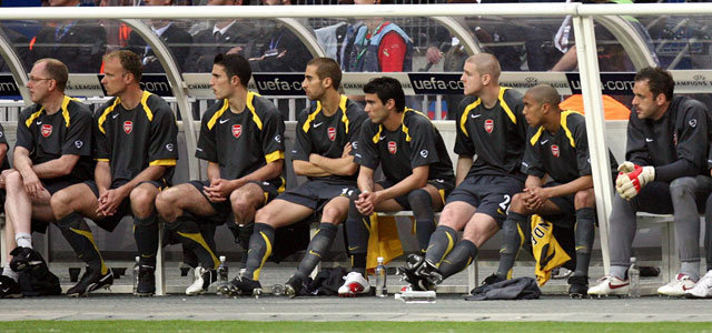 Dennis Bergkamp, Robin van Persie, Mathieu Flamini, Antonio Reyes, Philippe Senderos, Gaël Clichy en Manuel Almunia houden de bank van Arsenal warm tijdens de verloren Champions League-finale tegen Barcelona in 2006.