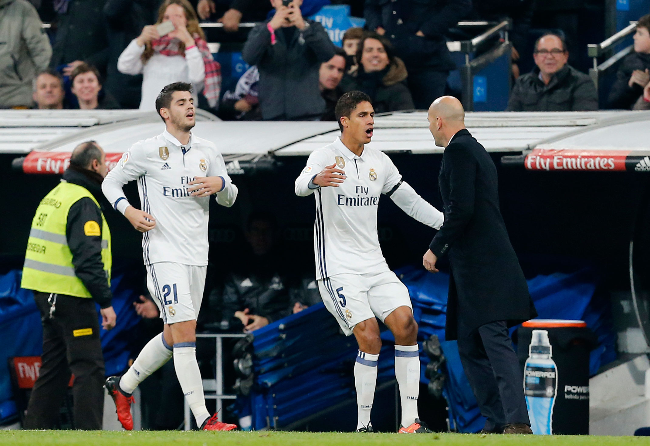 Raphaël Varane heeft zojuist de 2-0 gemaakt en viert zijn feestje met trainer Zinedine Zidane. De Franse trainer kreeg woensdag exact een jaar geleden de touwtjes in handen bij Real Madrid. Onder zijn leiding veroverde Real drie prijzen en werden slechts twee wedstrijden verloren. 