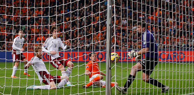 Klaas-Jan Huntelaar tikt de 3-0 binnen in het thuisduel met Letland, doelman Aleksandrs Kolinko is kansloos. Oranje won vorig jaar november eenvoudig met 6-0.