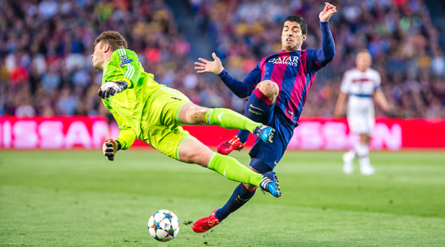 Beeld uit de heenwedstrijd tussen Barcelona en Bayern München, met Manuel Neuer en Luis Suarez.