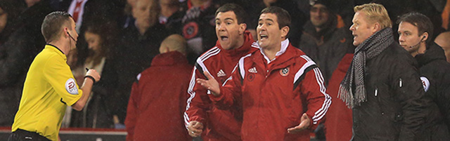 Ronald Koeman (rechts) ziet hoe stafleden van Sheffield United ruzie maken met scheidsrechter Chris Foy.