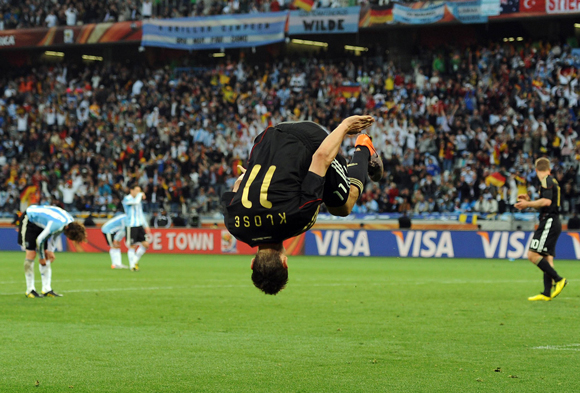 Miroslav Klose tijdens het WK 2010 in karakteristieke pose: al hangend in de lucht na weer een Klose-salto.