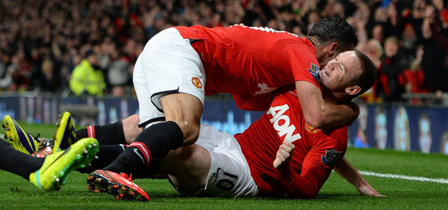 Robin van Persie vliegt aangever Wayne Rooney om de nek na de winnende goal tegen Arsenal.