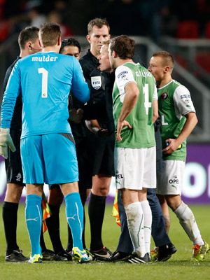 Serdar Gözübüyük en zijn assistenten worden belaagd door Feyenoord-trainer Ronald Koeman en Erwin Mulder, Joris Mathijsen en Jordy Clasie, die het niet eens zijn met de arbitrale beslissingen.