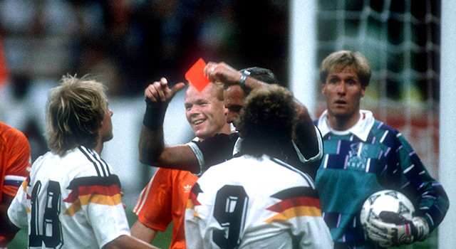 Jürgen Klinsmann staat er met zijn neus bovenop als scheidsrechter Juan Carlos Loustau de rode kaart trekt voor collega-spits Rudi Völler. Kort daarna zal ook Frank Rijkaard het veld moeten verlaten na het beruchte spuugincident. Ronald Koeman en Hans van Breukelen kijken op de achtergrond toe.