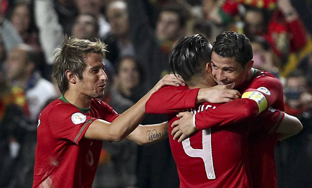Cristiano Ronaldo (rechts) viert zijn winnende treffer met Fábio Coentrão (links) en Miguel Veloso.