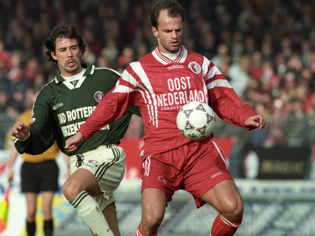 FC Twente kent een slechte eerste seizoenshelft in 1997/98. De ploeg staat na de 2-2 op bezoek bij Feyenoord op de tiende plaats in de competitie. Feyenoord staat weliswaar vijfde, maar heeft een achterstand van 23 punten op koploper Ajax. De Argentijn Pablo Sanchez kijkt toe hoe Rico Steinmann de bal controleert.