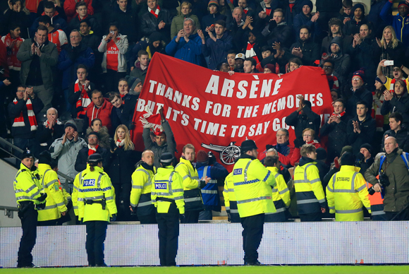 Arsenal-fans tonen hun onvrede met een spandoek gericht aan manager Arsène Wenger.
