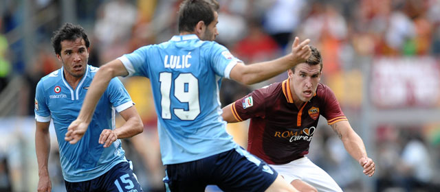 Kevin Strootman strijdt in zijn eerste Derby della Capitale om de bal met Lazio-middenvelders Álvaro González en Senad Lulic.