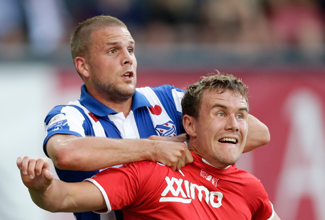 Ook FC Twente kan een verdiend punt bijschrijven. SC Heerenveen verdedigt zich in Enschede met hand en tand, maar ziet de door gelegenheidspits Joey van den Berg (links) verkregen voorsprong in de slotfase verloren gaan.