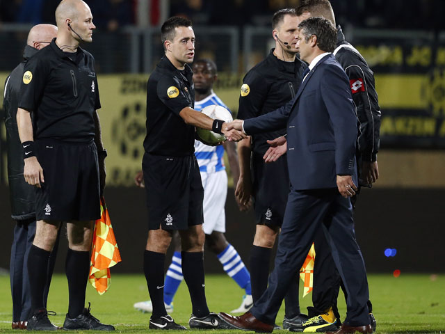 Hier geven ze elkaar een hand, maar Roda JC-trainer Ruud Brood heeft na het duel met PEC Zwolle (0-0) mede door rode kaarten voor Roly Bonevacia en Frank Demouge geen goed woord over voor arbiter Dennis Higler, die ook nog tijdelijk het duel moet staken omdat er plastic bekertjes op het veld worden gegooid.