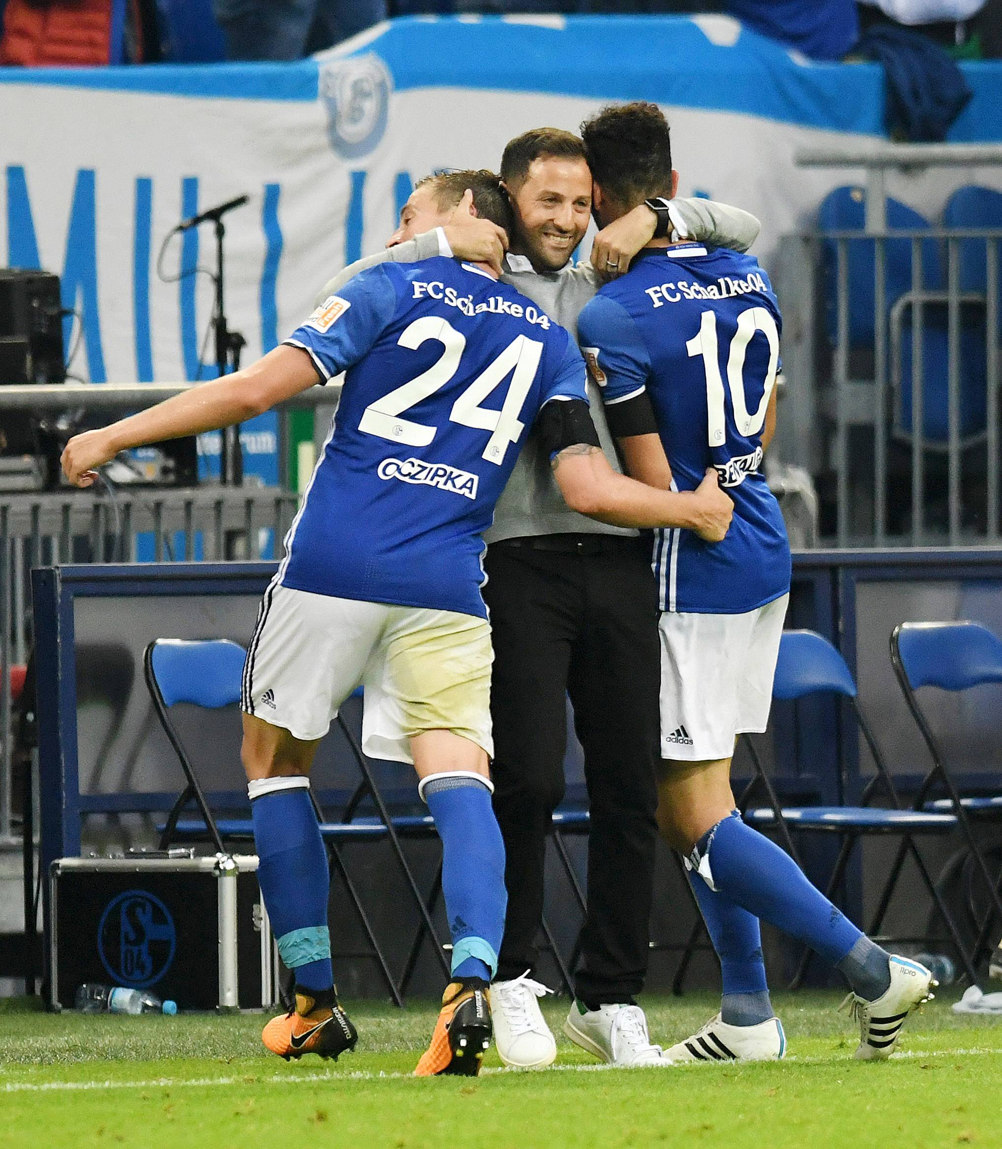 Domenico Tedesco kent een heerlijke start met Schalke 04, en knuffelt zijn spelers Bastian Oczipka en Nabil Bentaleb.