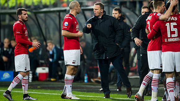 Trainer John van den Brom geeft Ron Vlaar aanwijzingen, rechts wordt het doelpunt van Mattias Johansson gevierd.