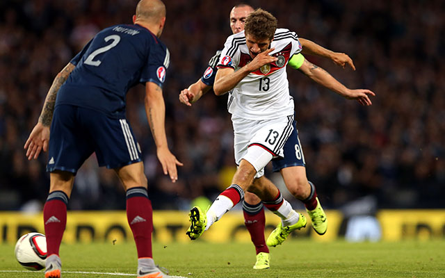 Thomas Müller is op weg naar de 0-1. Zijn schot zou via het been van Russell Martin in het Duitse doel belanden.