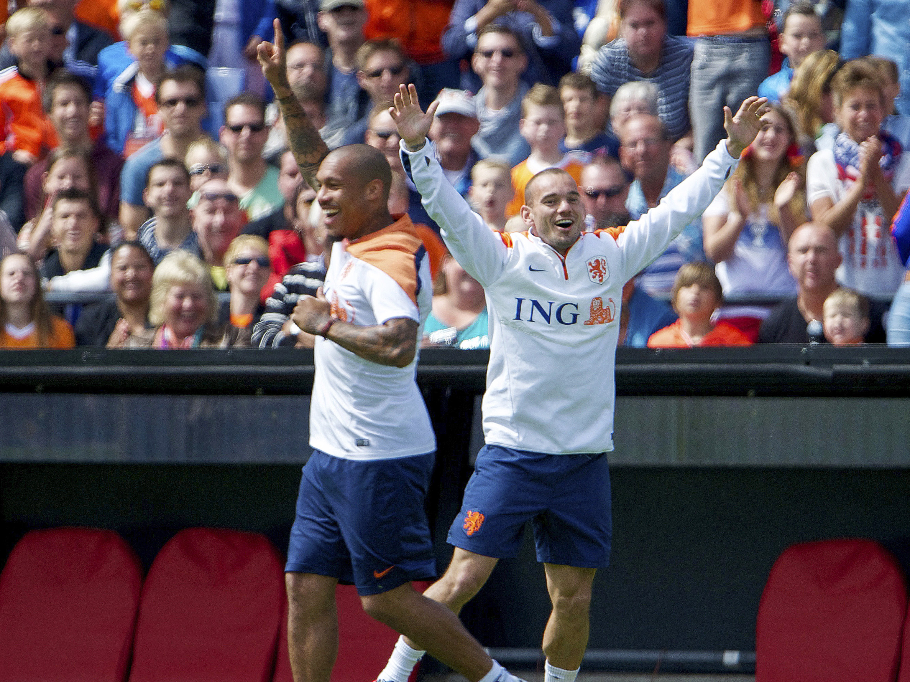 Routiniers Nigel de Jong en Wesley Sneijder hebben dolle pret op de training. Het publiek geniet mee.