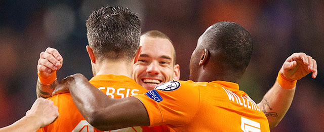 Jetro Willems (rechts) en Wesley Sneijder (midden) zijn blij met Robin van Persie (links) na zijn doelpunt.