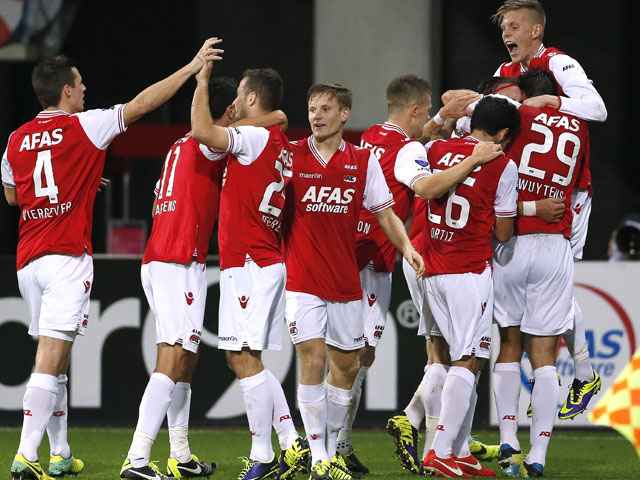 Nemanja Gudelj wordt na zijn doelpunt tegen ADO Den Haag bedolven onder feestende ploeggenoten. AZ wint met 2-0 van de Hagenaars en is de trotse koploper van de Eredivisie.