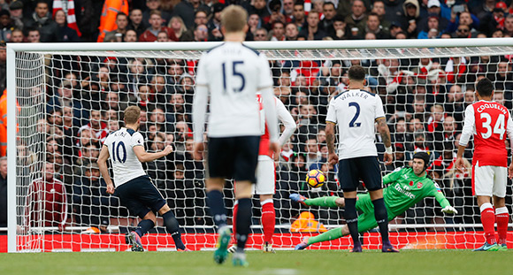 Harry Kane is trefzeker vanaf elf meter namens Tottenham, dat in de eerste helft nog was ontsnapt aan meer schade na de knal van Theo Walcott (Arsenal) op de lat.