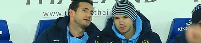 Edin Dzeko verbijt zich naast Frank Lampard op de bank van Manchester City.