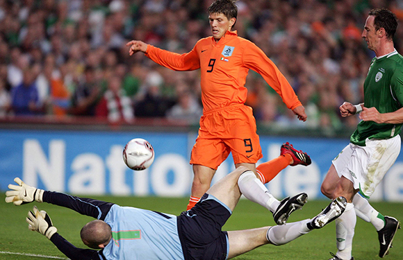 Klaas-Jan Huntelaar luistert zijn interlanddebuut op 16 augustus 2006 op met twee treffers in Dublin. Hier passeert hij Paddy Kenny voor de tweede keer (0-3).