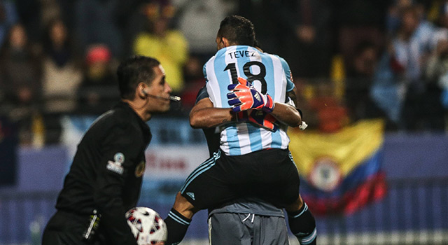 Carlos Tévez springt in de armen van doelman Sergio Romero na zijn beslissende penalty. Alles is vergeven en vergeten.