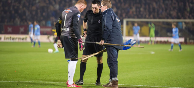 Jelle ten Rouwelaar moet al voor de wedstrijd aan de bak en toont van alle markten thuis te zijn. Hij helpt met het repareren van het veld.