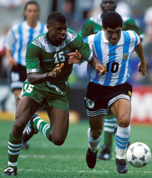 Diego Maradona in duel met ex-Ajacied Sunday Oliseh tijdens Argentinië - Nigeria (2-1) op het WK 1994 in de Verenigde Staten. Het was de laatste wedstrijd in de interlandloopbaan van Maradona, die na de wedstrijd tegen Nigeria op het gebruik van efedrine werd betrapt.