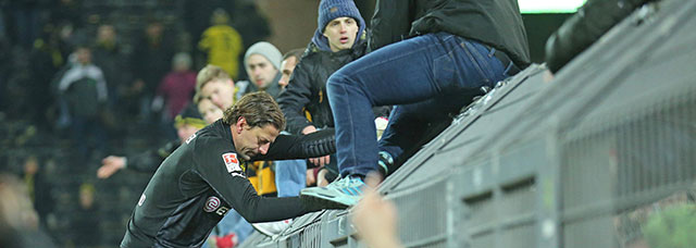 Roman Weidenfeller probeert de supporters van Borussia Dortmund gerust te stellen na de nederlaag tegen FC Augsburg op woensdagavond.